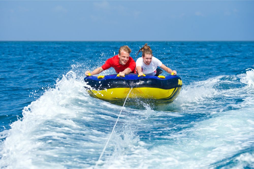 couple having fun riding the towable tube