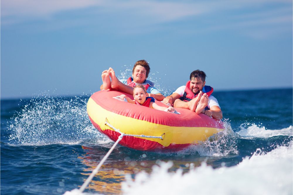 family having fun, riding on water tube